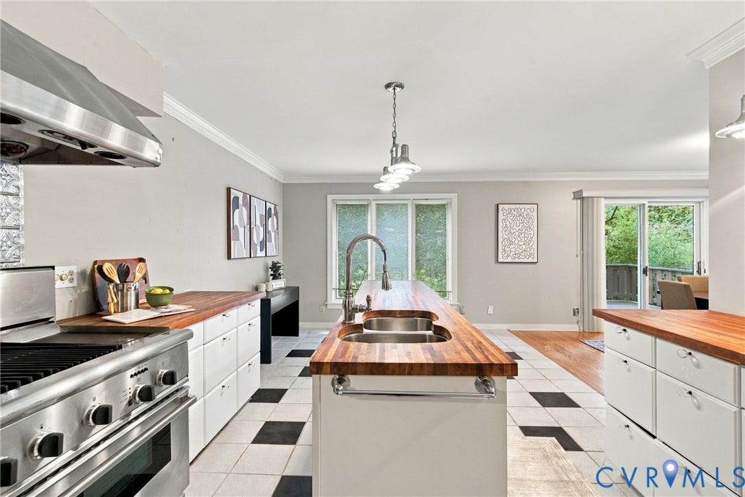 9015 Wood Sorrel Drive, Henrico, VA 23229 Kitchen featuring butcher block countertops, white cabinetry, stainless steel professional-style gas range with matching hood, kitchen island with dual basin sink, and geometric tile flooring