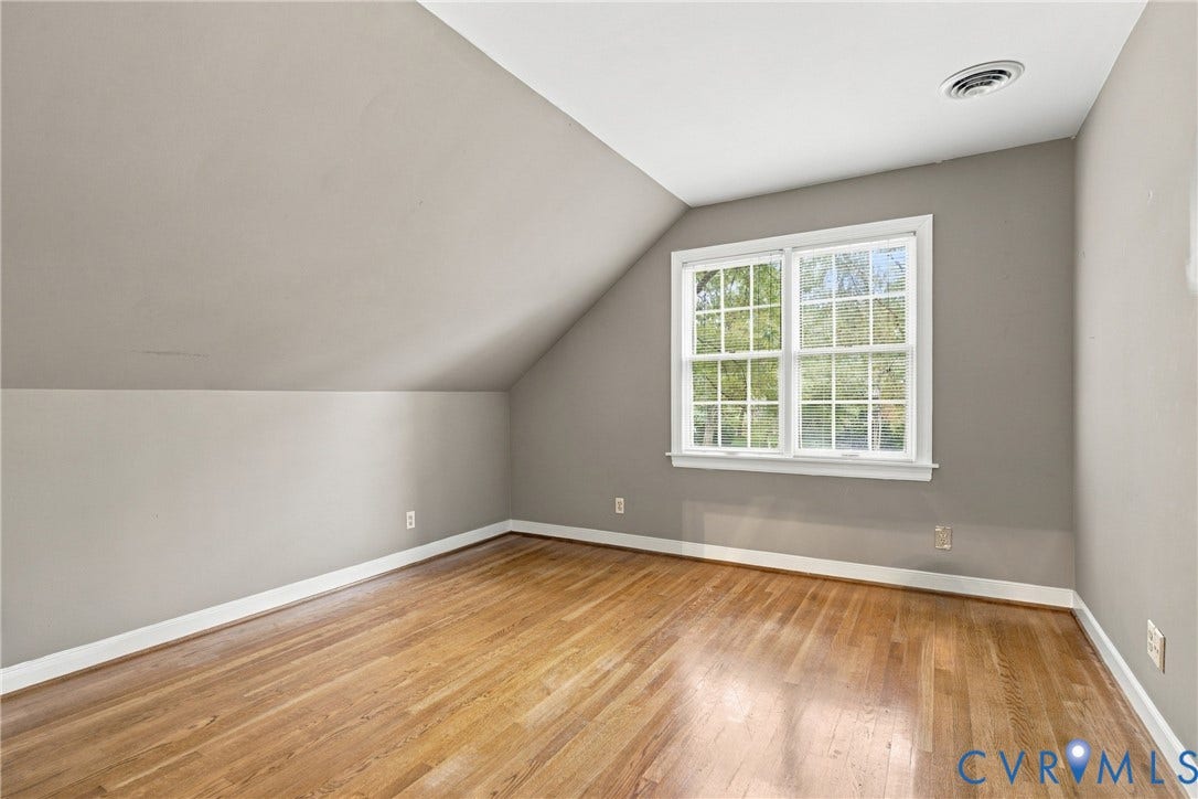 9015 Wood Sorrel Drive, Henrico, VA 23229 Neutral-toned walls featuring a vaulted ceiling and wood-finish flooring with a multi-pane grid window