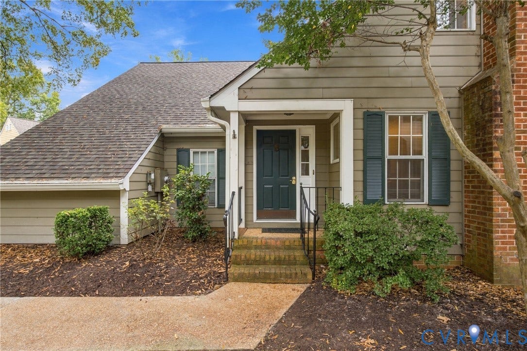 9015 Wood Sorrel Drive, Henrico, VA 23229 Exterior facade featuring horizontal siding, multi-pane windows with decorative shutters, a brick chimney, and a covered entryway with brick stairs