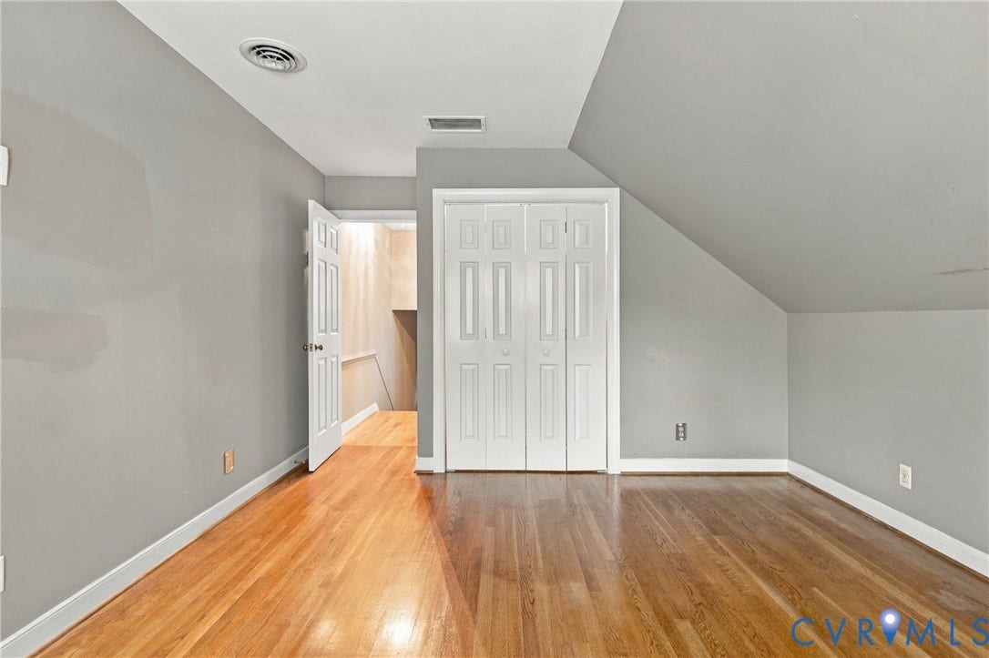 9015 Wood Sorrel Drive, Henrico, VA 23229 Room featuring wood-finish flooring, white paneled bifold closet doors, and angled ceiling architecture