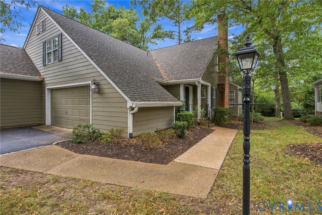 9015 Wood Sorrel Drive, Henrico, VA 23229 Exterior featuring horizontal siding, a multi-gabled roofline, an attached garage, a brick chimney, and a concrete walkway
