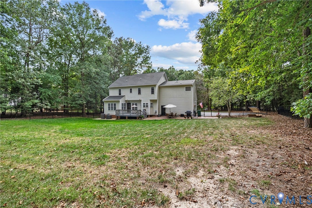 8406 Chandon Court, Chesterfield, VA 23838 Expansive backyard featuring a deck, brick patio, and mature trees