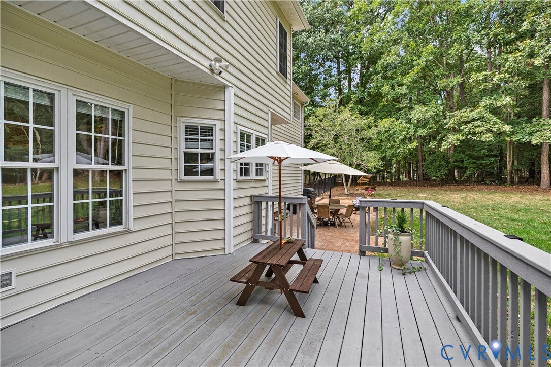 8406 Chandon Court, Chesterfield, VA 23838 Exterior siding, a spacious deck, an expansive lawn, and mature trees define the outdoor space