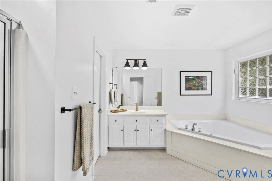 8406 Chandon Court, Chesterfield, VA 23838 White vanity with gold-finish hardware, a large mirror, and three-light sconce