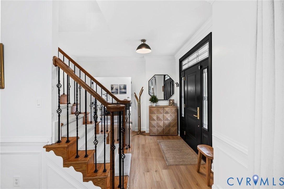 8406 Chandon Court, Chesterfield, VA 23838 Hardwood flooring, black paneled entry door with transom window, staircase with wrought iron spindles and wood handrail, wainscoting, and crown molding