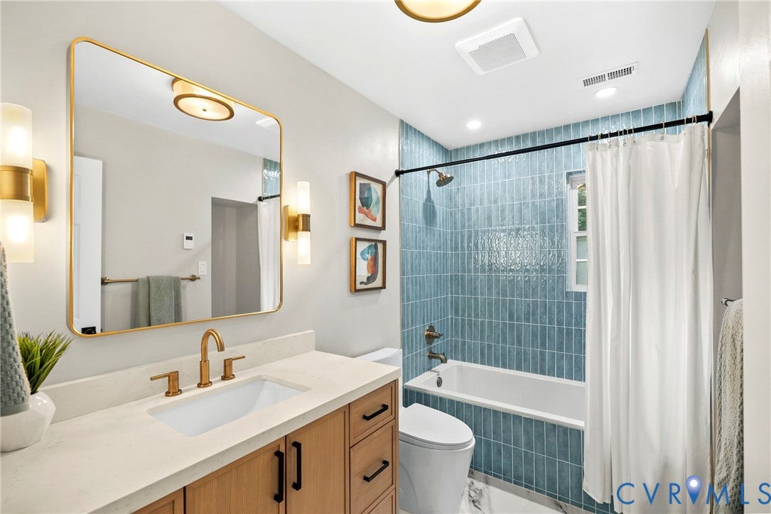 8406 Chandon Court, Chesterfield, VA 23838 Bathroom featuring a wood-finish vanity with a light-toned countertop, a rectangular undermount sink with a brass-finish faucet, and a large framed mirror