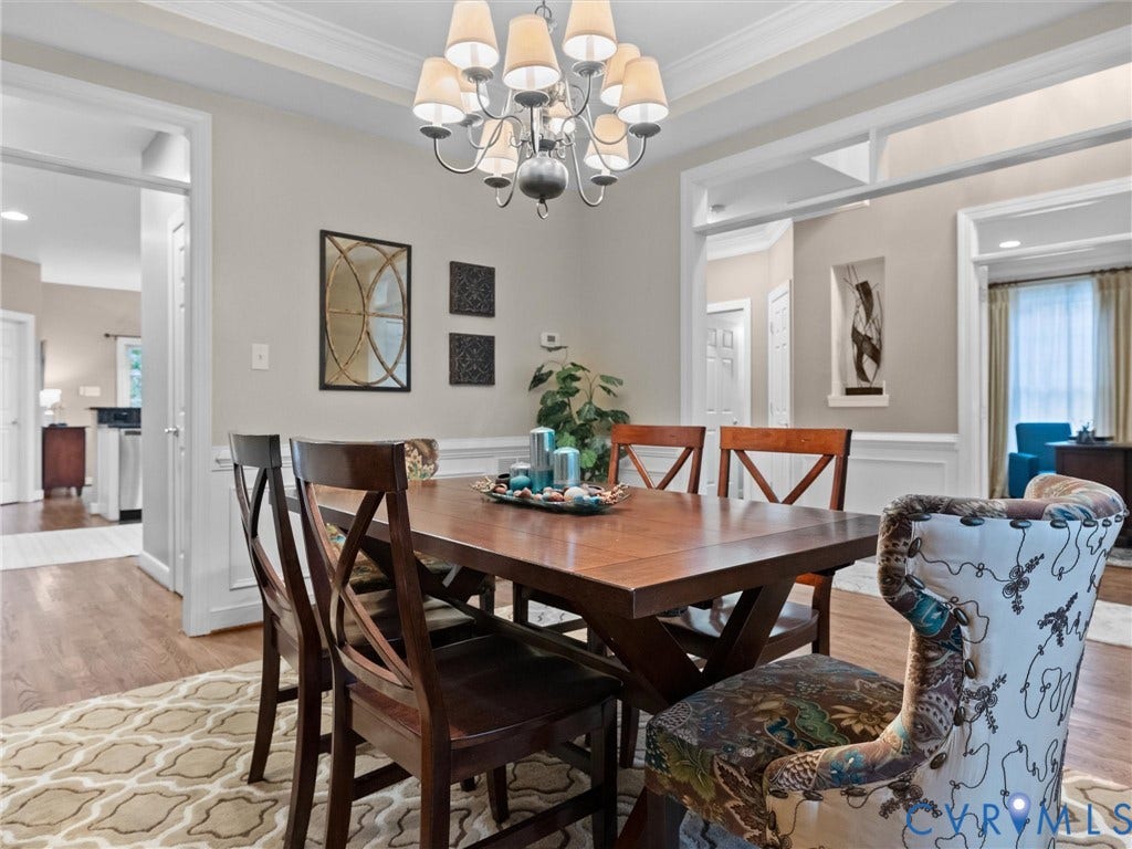14779 Rolling Spring Drive, Charter Colony, Midlothian, VA 23114 A gracious formal dining room designed for gathering, with beautiful hardwood floors, classic wainscoting, substantial crown molding and elegant architectural detailing. Generously sized for entertaining, yet warm and inviting enough for everyday dinners and celebrations with family and friends