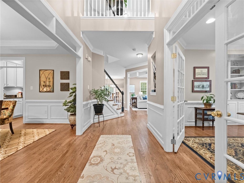 14779 Rolling Spring Drive, Charter Colony, Midlothian, VA 23114 A gracious two-story foyer immediately showcases the homes exceptional craftsmanship, with gleaming hardwood floors, classic millwork, wainscoting and substantial crown molding. An open second-floor gallery adds architectural interest, while French doors lead to a private home office and the adjoining formal spaces flow effortlessly into the heart of the home. Elegant, timeless and beautifully maintained.