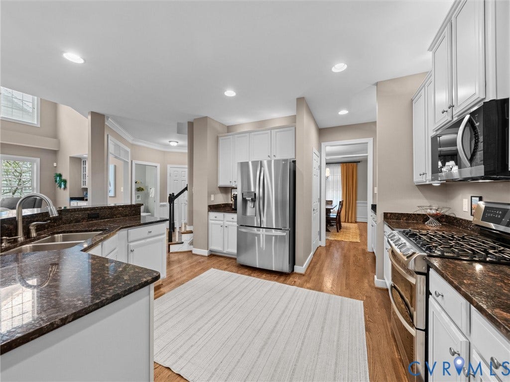 14779 Rolling Spring Drive, Charter Colony, Midlothian, VA 23114 Beautifully renovated kitchen where timeless design meets everyday functionality, featuring crisp white cabinetry, expansive countertops, stainless appliances and a generous center island. Recessed lighting and abundant natural light keep the space bright and airy, while the open layout creates an effortless connection to the adjoining living and dining areasequally suited for entertaining and everyday life