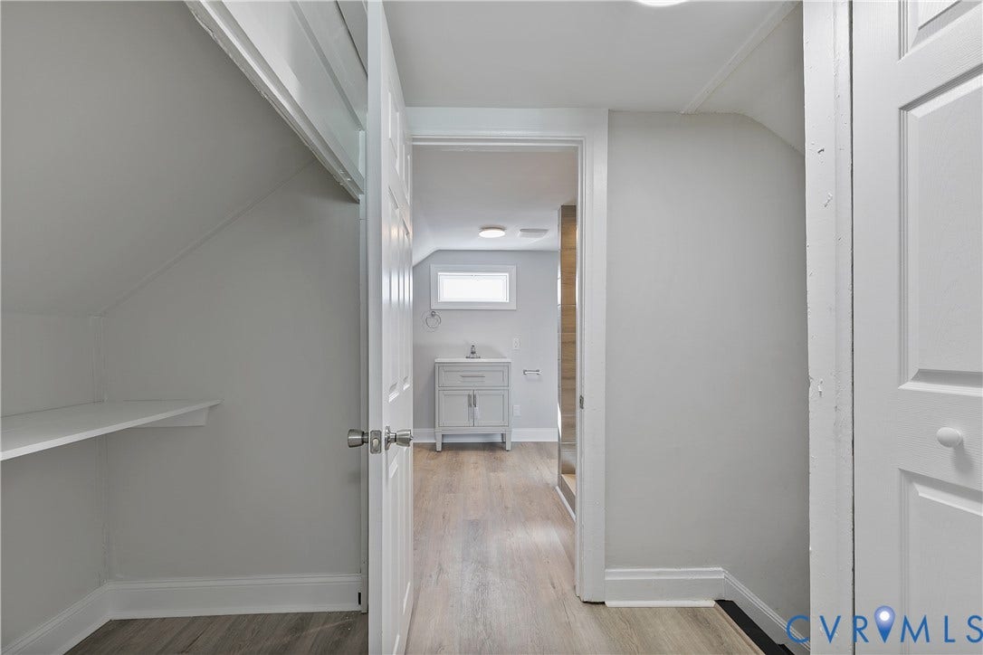 1305 Overlook Street, Richmond, VA 23224 Open doorway leading to a room with wood-finish flooring, a vanity with storage, and a rectangular window