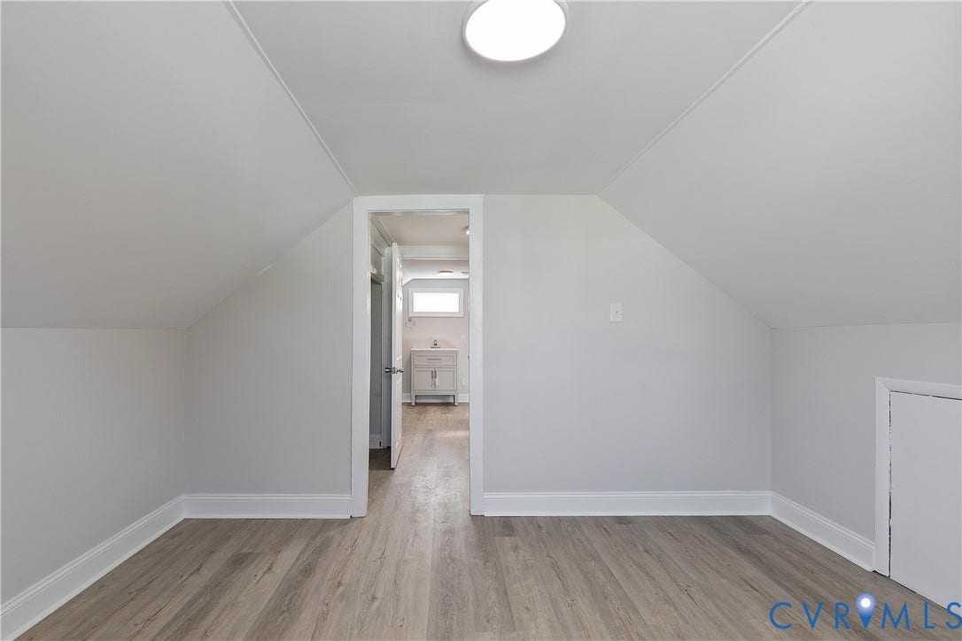 1305 Overlook Street, Richmond, VA 23224 Wood-finish flooring, white walls, angled ceilings, and a built-in storage door
