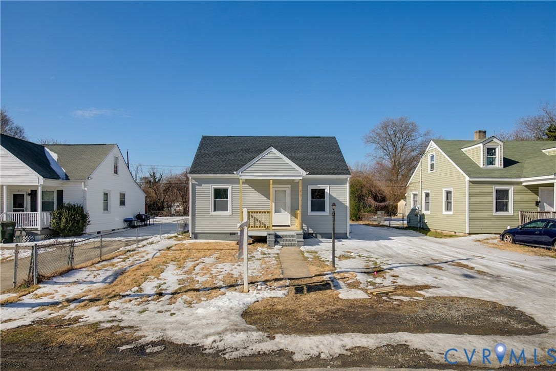1305 Overlook Street, Richmond, VA 23224 Exterior featuring light gray siding, dark shingle roofing, and a front porch with natural wood railings