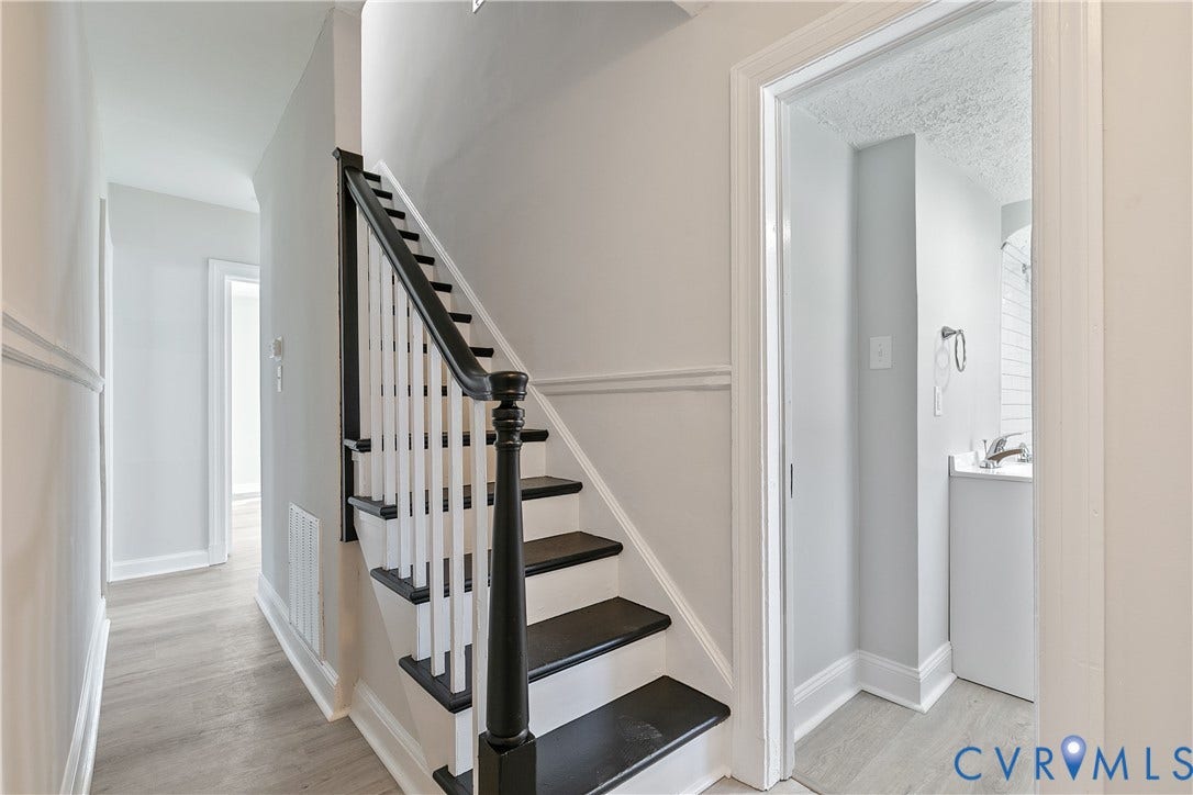 1305 Overlook Street, Richmond, VA 23224 Two-tone staircase with dark treads and white risers, wood-finish flooring, and light wall tones