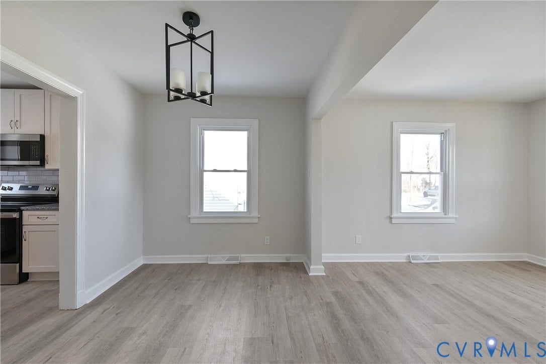 1305 Overlook Street, Richmond, VA 23224 Light gray walls, wood-finish flooring, white window trim, and a black geometric light fixture