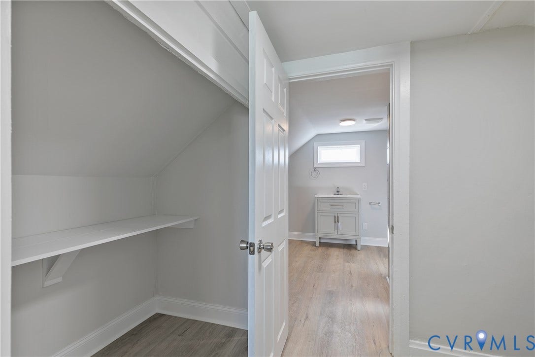1305 Overlook Street, Richmond, VA 23224 Built-in shelving, wood-finish flooring, white paneled door, and a vanity with a rectangular sink