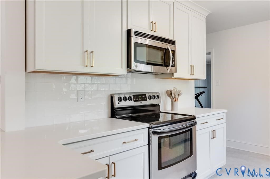2304 Buckingham Avenue, Henrico, VA 23228 White shaker-style cabinetry with gold-finish hardware, subway tile backsplash, and light-toned countertops