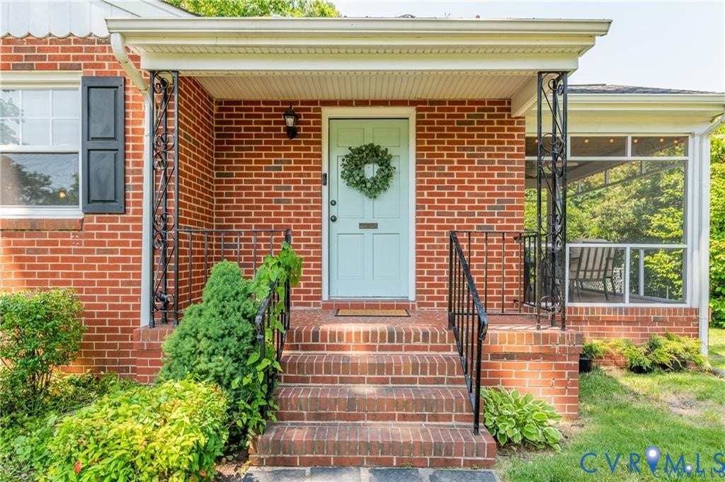 2304 Buckingham Avenue, Henrico, VA 23228 Brick exterior with a light blue entry door, an exterior wall light fixture, and black louvered shutters