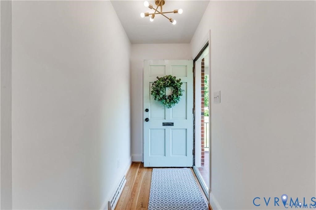 2304 Buckingham Avenue, Henrico, VA 23228 Light wood-finish flooring with a light blue door, an overhead light fixture, and a partial glass-paneled door