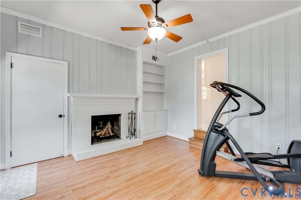2304 Buckingham Avenue, Henrico, VA 23228 Fireplace with painted brick surround, wood-finish flooring, ceiling fan, and built-in shelving