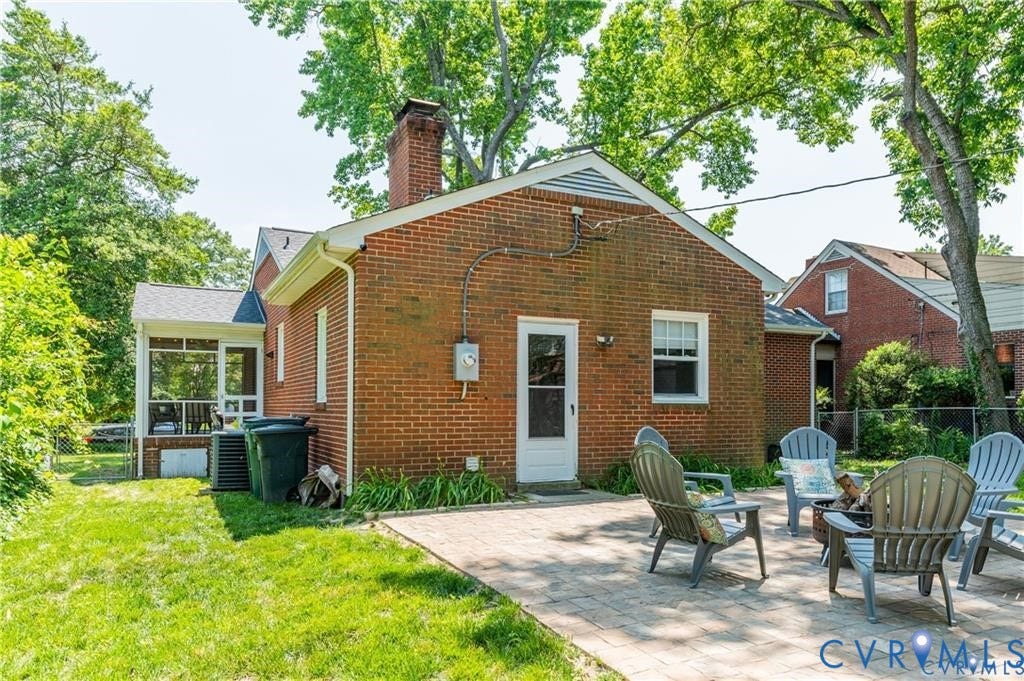 2304 Buckingham Avenue, Henrico, VA 23228 Brick exterior with a screened porch, a paver patio, a white rear entry door, and a single-pane window