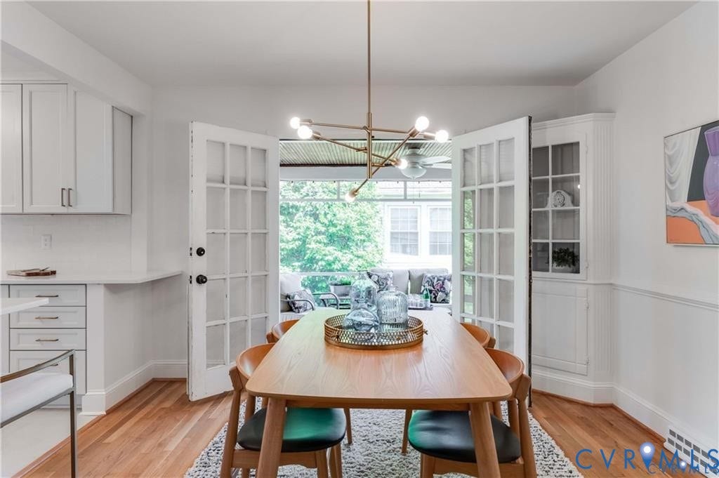 2304 Buckingham Avenue, Henrico, VA 23228 Hardwood flooring, white built-in corner cabinet, white upper and lower cabinetry, white countertops, and French doors leading to a screened porch