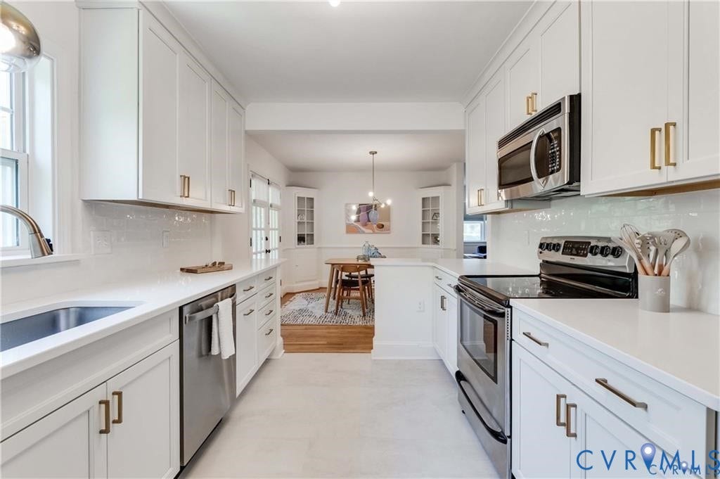 2304 Buckingham Avenue, Henrico, VA 23228 Galley kitchen featuring white cabinetry, stainless steel appliances, white countertops, and a subway tile backsplash