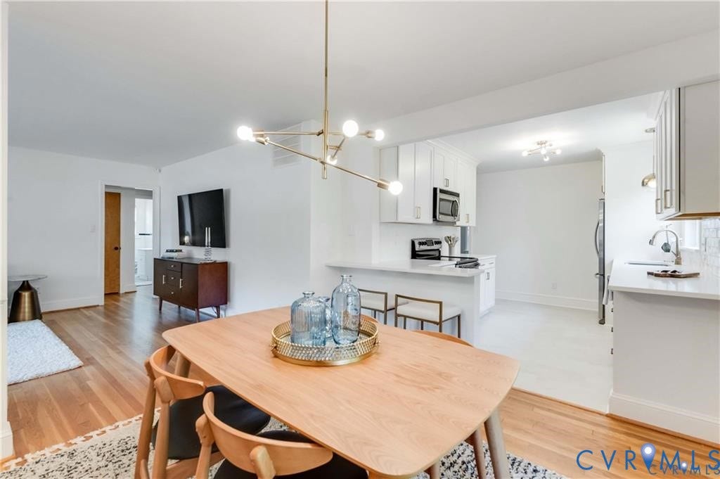 2304 Buckingham Avenue, Henrico, VA 23228 Hardwood flooring, contemporary lighting fixture, white kitchen cabinetry, stainless steel microwave, and white countertops
