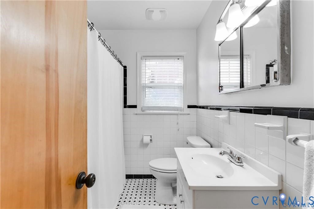 2304 Buckingham Avenue, Henrico, VA 23228 White tiled bathroom featuring a built-in vanity with a white countertop and integrated sink