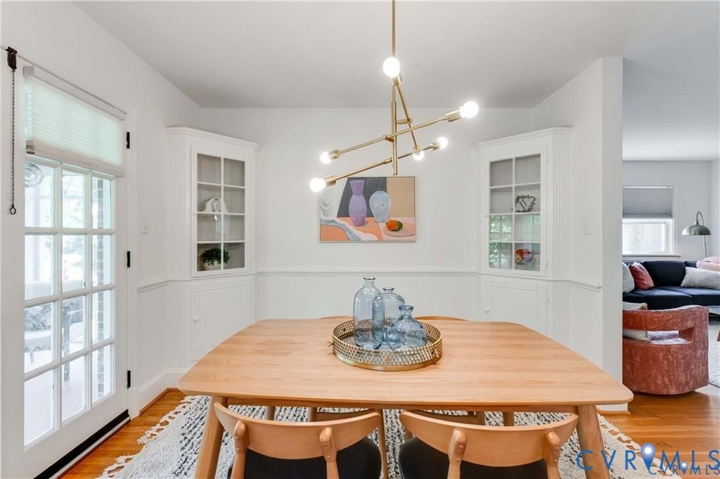 2304 Buckingham Avenue, Henrico, VA 23228 Hardwood flooring, painted paneled walls, two built-in corner display cabinets with glass fronts, and a modern chandelier