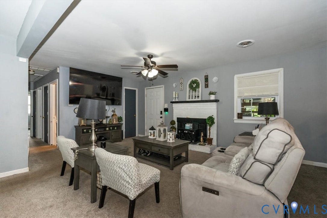 5510 Alberta Road, Stanwick, Midlothian, VA 23832 Living space featuring carpet flooring, a ceiling fan with integrated lighting, a white painted fireplace with a dark insert, and a window with blinds