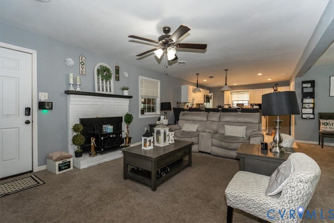 5510 Alberta Road, Stanwick, Midlothian, VA 23832 Living area featuring a ceiling fan with light fixture, white brick fireplace, and an open concept layout with visibility to the kitchen