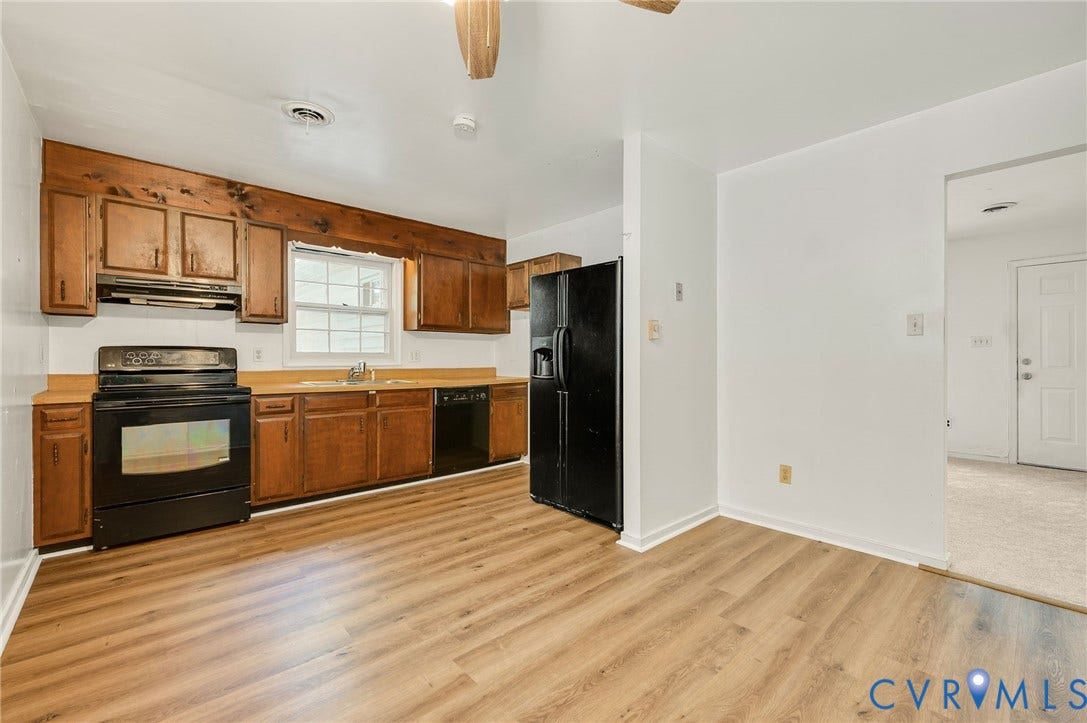 Kitchen featuring wood-finish flooring, wood cabinetry, a black electric range, and a black refrigerator