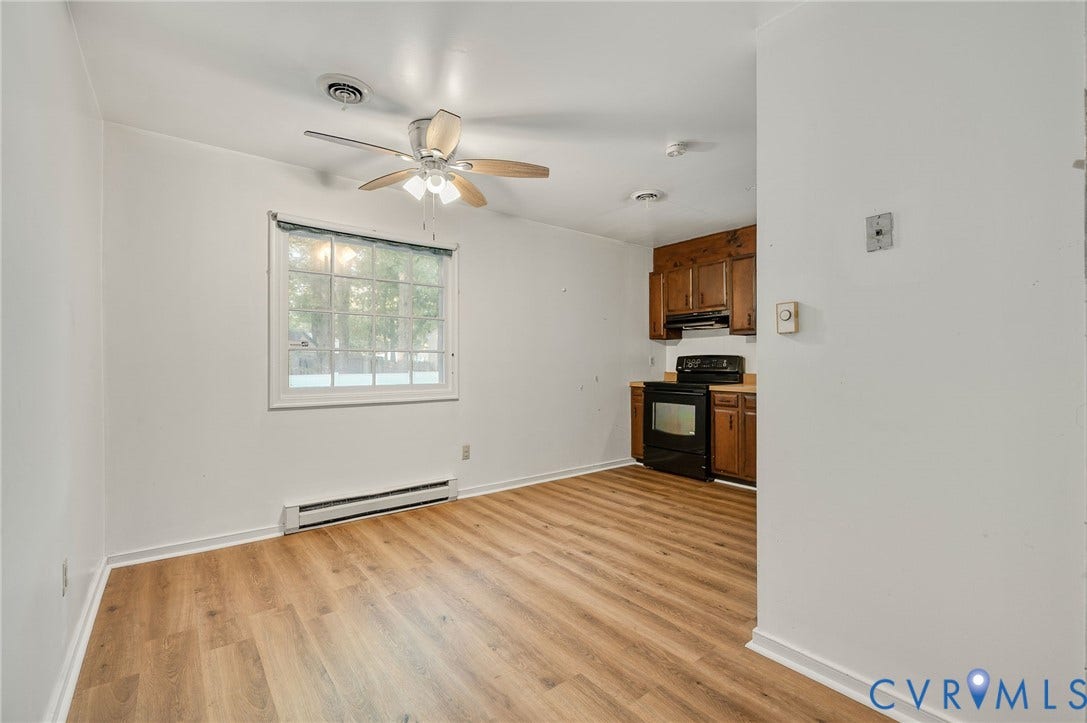 Wood-finish flooring, white walls, and a ceiling fan with integrated lighting