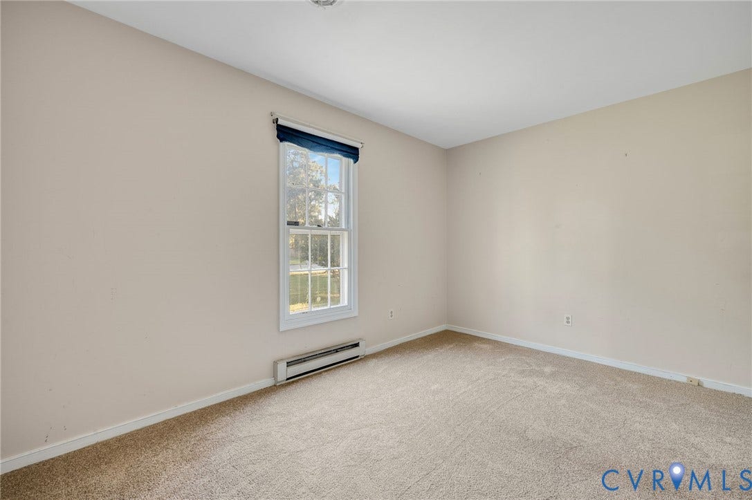 Neutral wall paint, carpet flooring, and a double-hung window