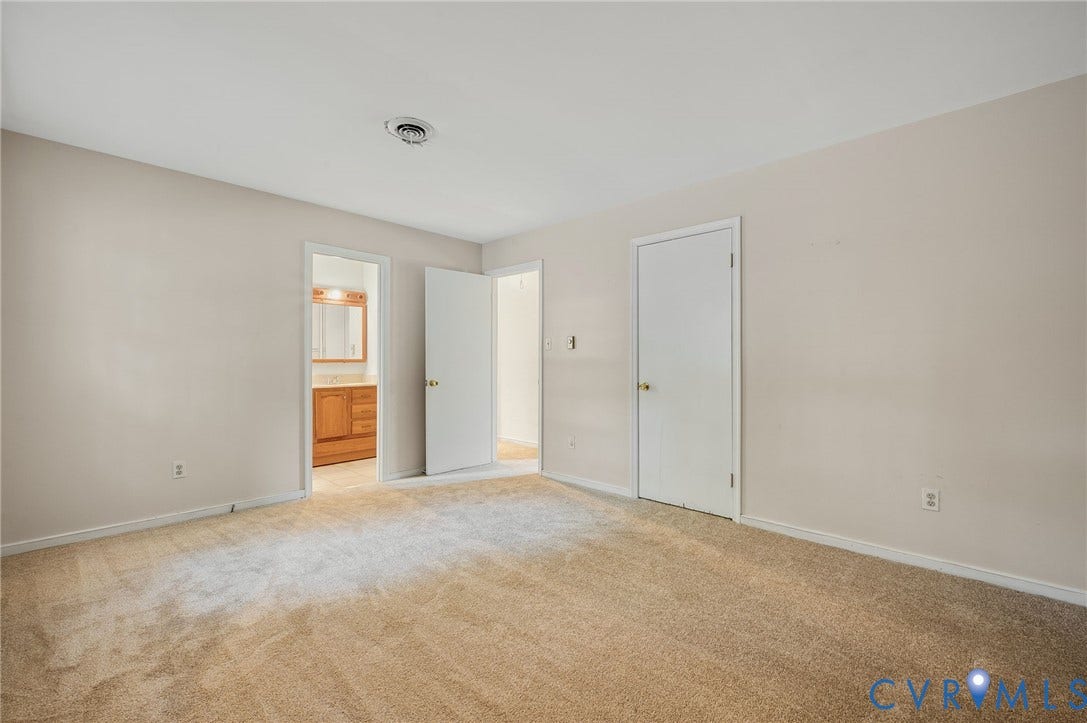 Neutral-toned walls complement the light-colored carpeting