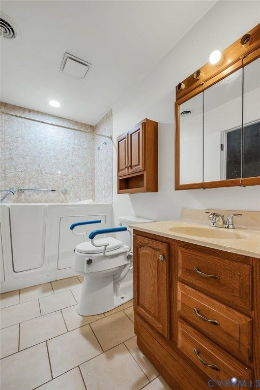 Tile flooring, wood-finish vanity with an integrated sink, walk-in tub with tile surround, and a wall-mounted medicine cabinet