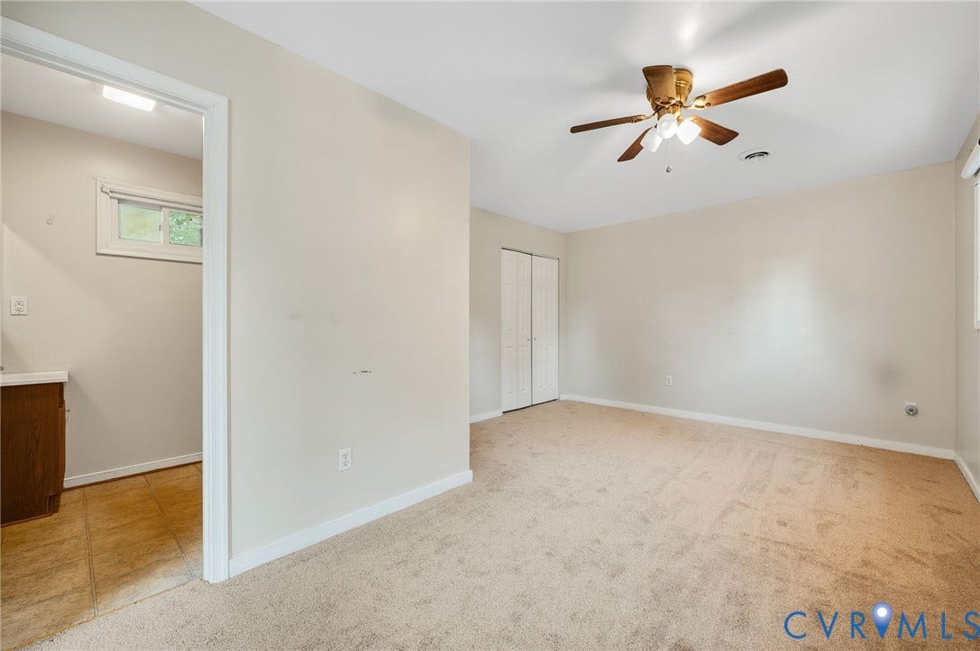 Carpeted flooring, ceiling fan with integrated lighting, bi-fold closet doors, and neutral wall paint