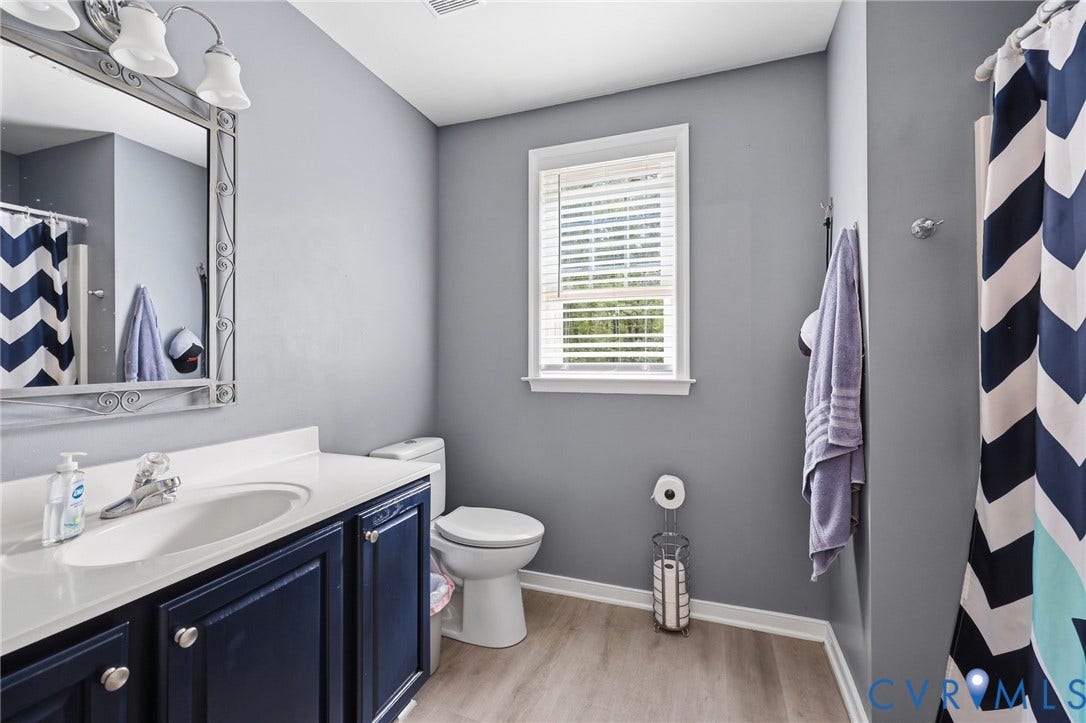 Vanity with dark wood-finish cabinetry, white countertop, and integrated sink