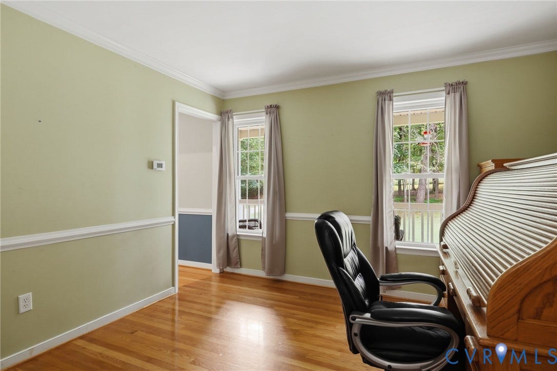 Hardwood flooring, wall trim, crown molding, and multiple windows with white sashes