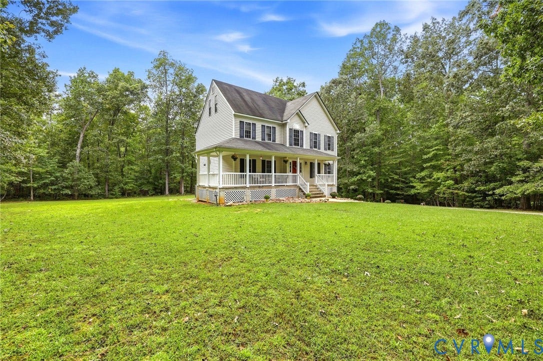 Two-story residence with a covered front porch featuring white railings