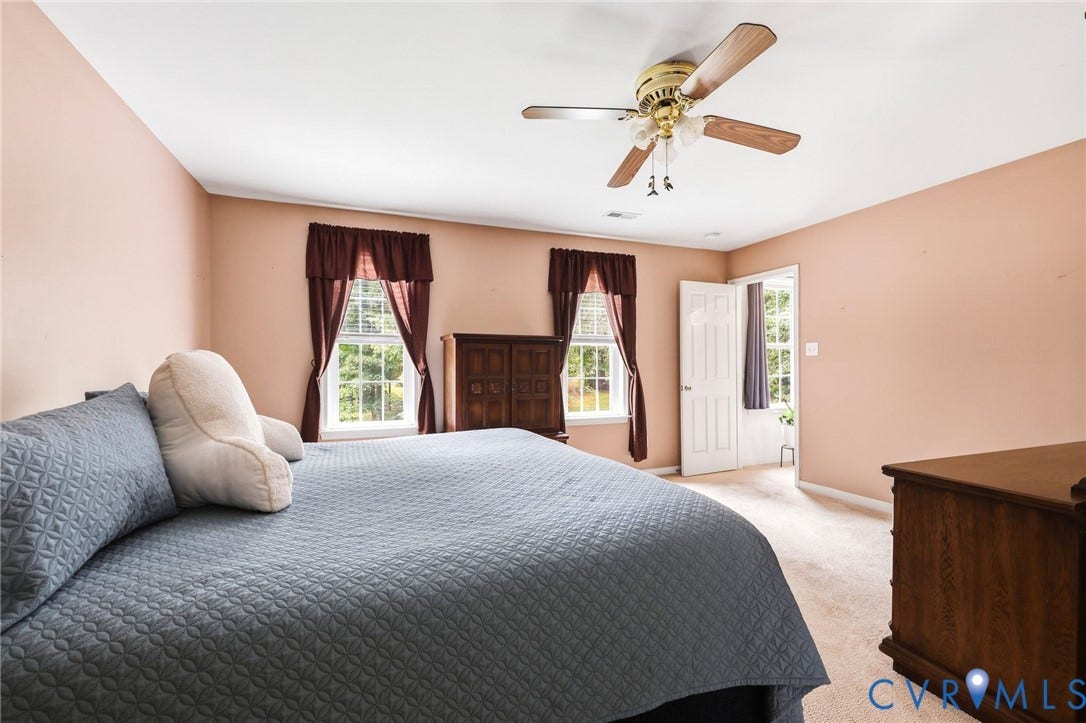 Recessed windows with natural light, ceiling fan with light fixture, light-colored carpeting, white interior doors