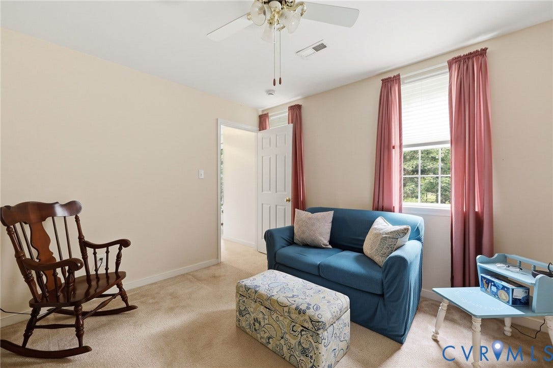 Carpeted room with neutral wall paint and a ceiling fan