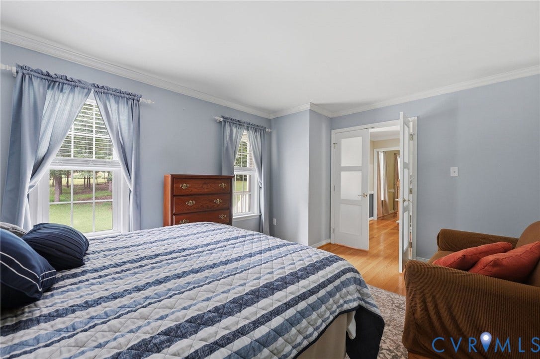 Recessed lighting, crown molding, and two multi-pane windows with white blinds