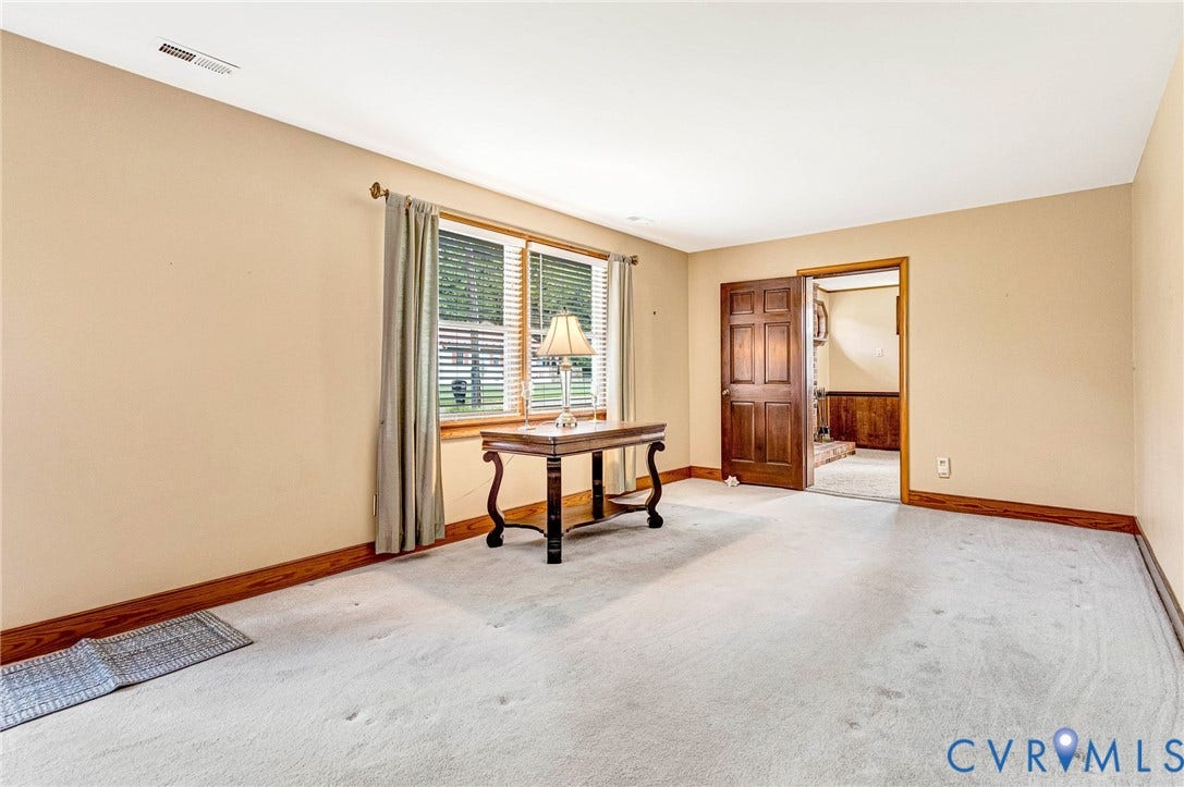 Carpeted flooring with base molding, neutral wall color.