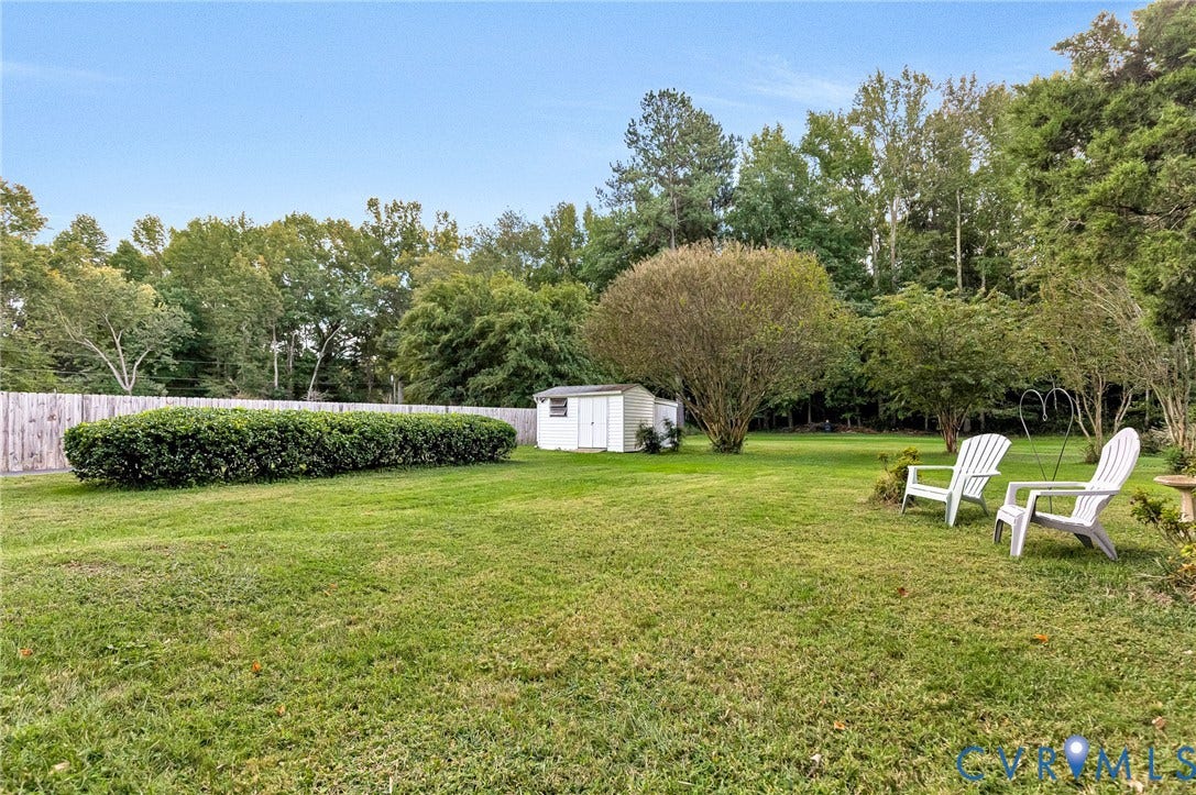 Expansive lawn with mature trees and a privacy fence