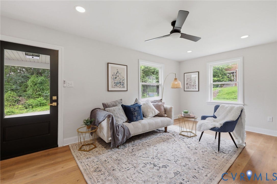 Recessed lighting, ceiling fan, wood-finish flooring, white trim, and a black exterior door with clear glass panel