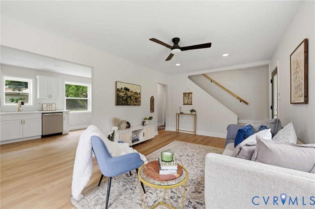 Open-concept living area with wood-finish flooring, recessed lighting, and a ceiling fan