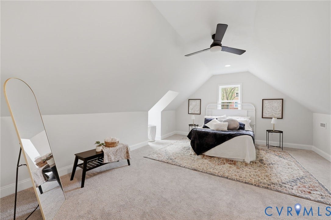 Sloping ceiling with recessed lighting, ceiling fan, carpeting, and a window