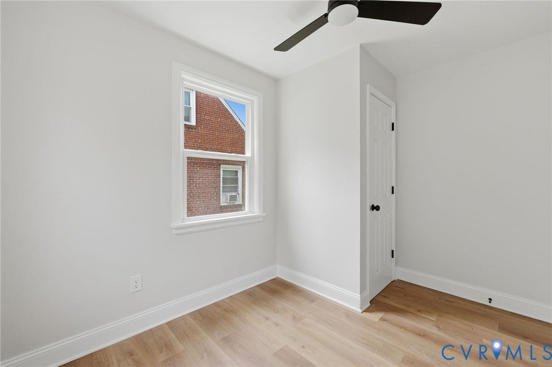 Wood-finish flooring, white walls, and a contemporary ceiling fan