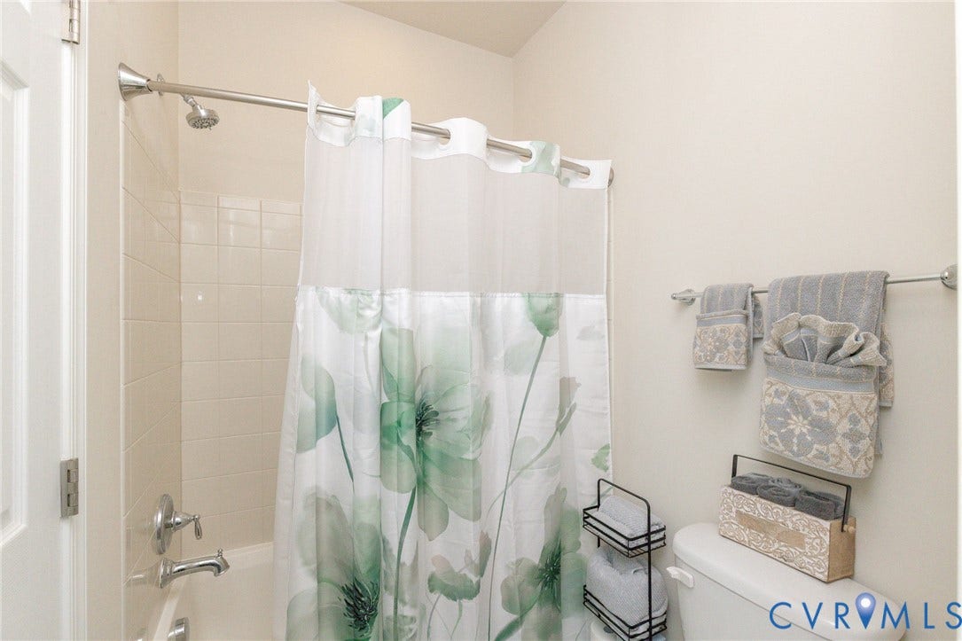 Bathtub with white tile surround and chrome fixtures